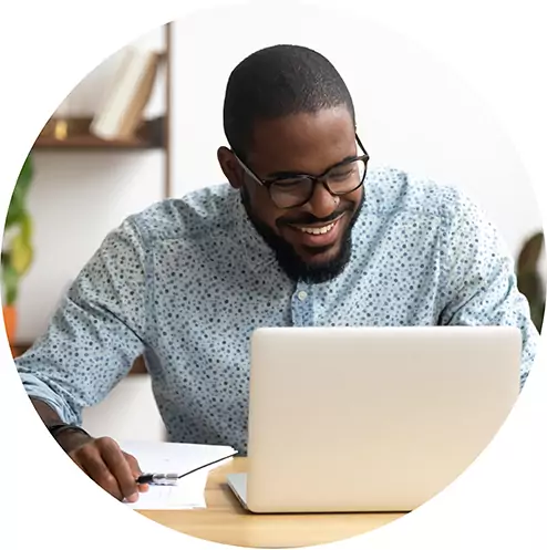 Head shot smiling african-american manager using laptop looking at screen